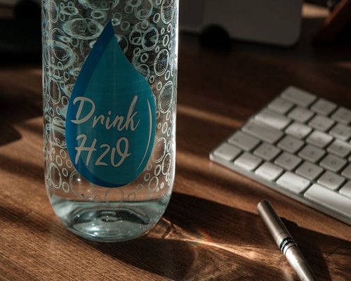 A clear glass of drinking water on a wooden desk